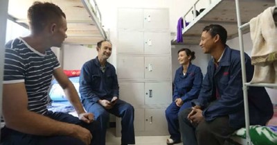 A couple recruited through a labor transfer program is sitting in a bunk room at a facility of Hoshine Silicon Industry Co., Ltd.