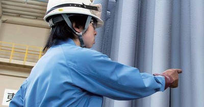 Worker with polysilicon rods at polysilicon plant of Osaka Titanium Technologies in Japan