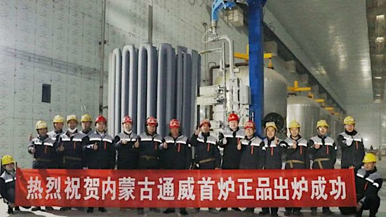 Technicians in front of polysilicon rods from the first successful run of a chemical vapor deposition (CVD) reactor in the factory of Inner Mongolia Tongwei High-Purity Polysilicon Co., Ltd. in Baotou, Inner Mongolia, China